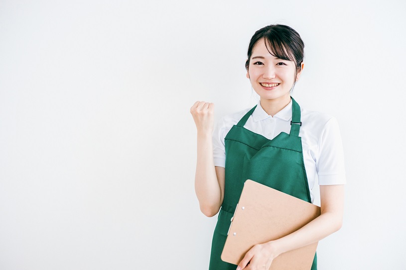 ガッツポーズをするエプロン女性